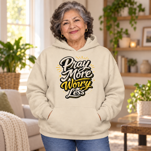 Older woman wearing sand Pray More Worry Less hoodie in a warm living room